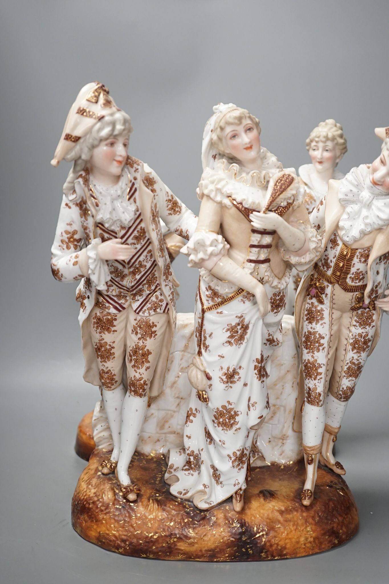 A pair of large French porcelain figures, 38cm, and a figural group en suite